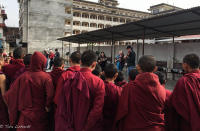 Tour members performing some tunes for young monks at a monastery 